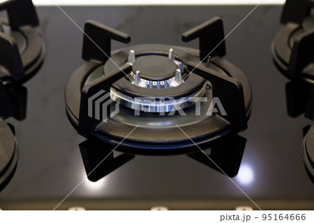 Modern kitchen and black glass ceramic built-in gas oven detail Modern kitchen and black glass ceramic built-in gas oven detail 95164666