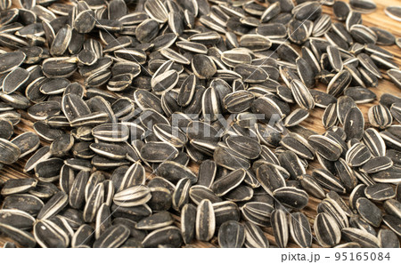 Sunflower Seeds, Striped Raw Seeds on Wood Background Texture Closeup Sunflower Seeds, Striped Raw Seeds on Wood Background Texture Closeup 95165084