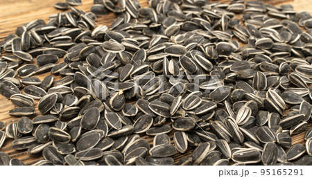Sunflower Seeds, Striped Raw Seeds on Wood Background Texture Closeup Sunflower Seeds, Striped Raw Seeds on Wood Background Texture Closeup 95165291