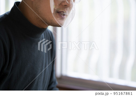 フェイスシールドをして話す中年男性 フェイスシールドをして話す中年男性 95167861