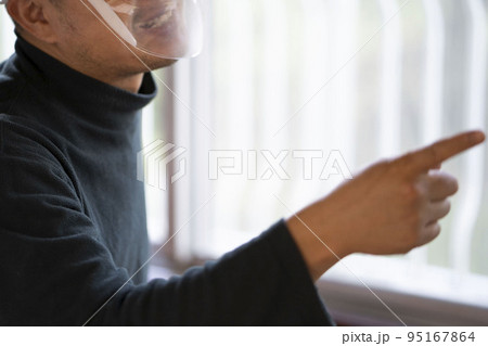 フェイスシールドをして怒る中年男性 95167864