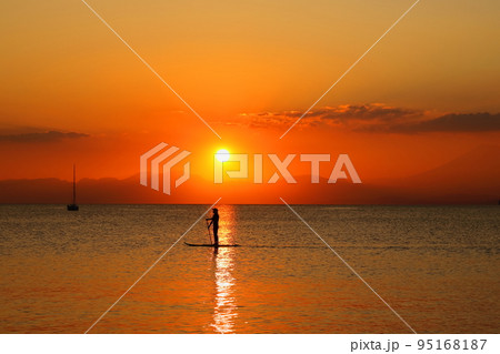 逗子海岸の夕暮れ、夕焼けの中SUPを楽しむ若者のシルエット 逗子海岸の夕暮れ、夕焼けの中SUPを楽しむ若者のシルエット 95168187