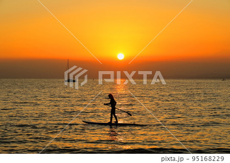 夕暮れの逗子海岸、SUPを楽しむ子どものシルエット 夕暮れの逗子海岸、SUPを楽しむ子どものシルエット 95168229