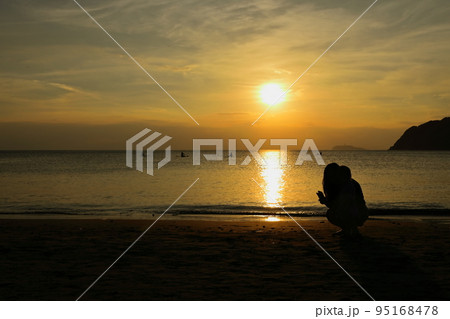 夕暮れの逗子海岸、波打ち際でたたずむ親子のシルエット 95168478