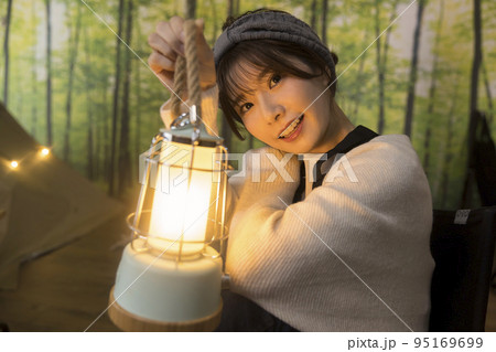 ランタンを持つ若い女性　家キャン　おうちキャンプ 95169699