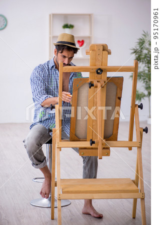 Young man enjoying painting at the studio 95170961