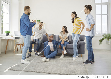 Group of diverse friends meeting in living room, talking and listening to each other Group of diverse friends meeting in living room, talking and listening to each other 95172461