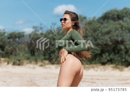 Attractive woman standing on seashore 95173785