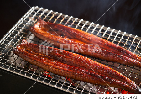 炭火で鰻の蒲焼を焼く 95175473