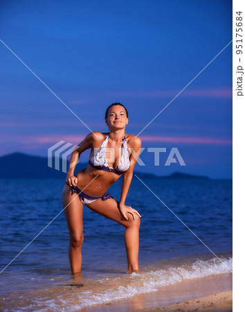 Sexy girl posing on the tropical beach at sunset - Stock Photo [95175684] -  PIXTA