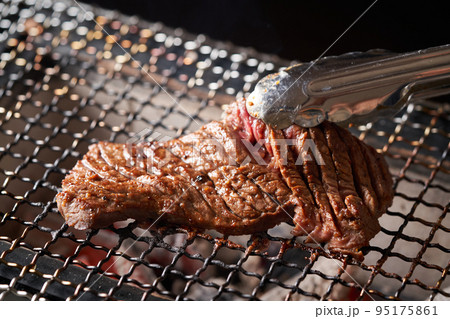 切り込みの入った牛肉を焼く 95175861