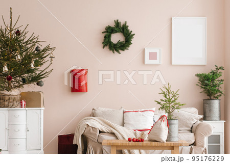 Stylish Christmas living room interior with sofa, tree and wreath, mailbox, gifts and decorations. Festive time for the family. Stylish Christmas living room interior with sofa, tree and wreath, mailbox, gifts and decorations. Festive time for the family. 95176229