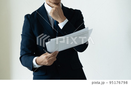 書類を見て悩むビジネスマン 95176798