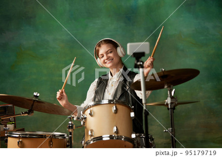 Mood, tone, atmosphere. Young girl, rock musician recording music video blog home lesson, playing drums or making broadcast internet tutorial 95179719
