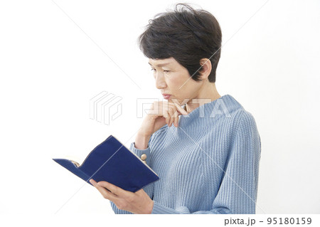 読書中に考える中年女性　白背景 95180159