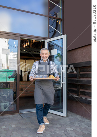 Waiter carrying a tray with breakfast to the suctomer Waiter carrying a tray with breakfast to the suctomer 95183210