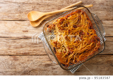 Delicious homemade Jerusalem kugel with noodles, raisins, cinnamon and sugar close-up in a glass bowl. Horizontal top view 95183587