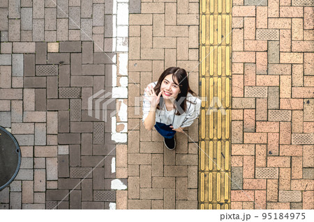 街中を散歩する若い女性 手を振る 俯瞰撮影 街中を散歩する若い女性 手を振る 俯瞰撮影 95184975
