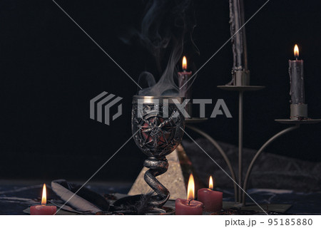 Witchcraft composition with burning candles, jewelry and pentagram symbol. Halloween and occult concept, black magic ritual. Witchcraft composition with burning candles, jewelry and pentagram symbol. Halloween and occult concept, black magic ritual. 95185880