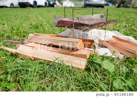 芝生のキャンプ場と焚き火用の薪 95186180