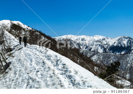 福井県取立山にて春残雪期登山：山頂を目指す登山者 95186367