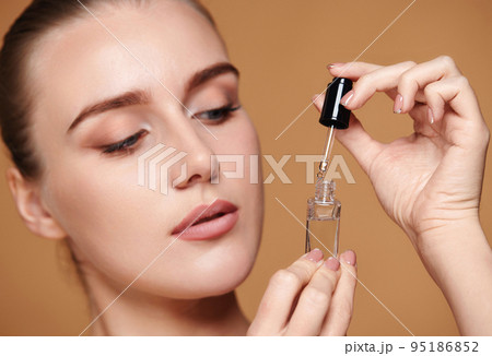 woman holding bottle with serum for skin care woman holding bottle with serum for skin care 95186852