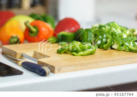 Cutting green bell pepper, cooking, food and home concept. Cutting board at home 95187764