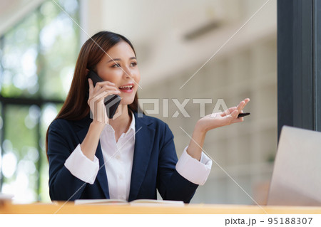 Asian Business woman making business call talking on phone. Account and Finance concept Asian Business woman making business call talking on phone. Account and Finance concept 95188307