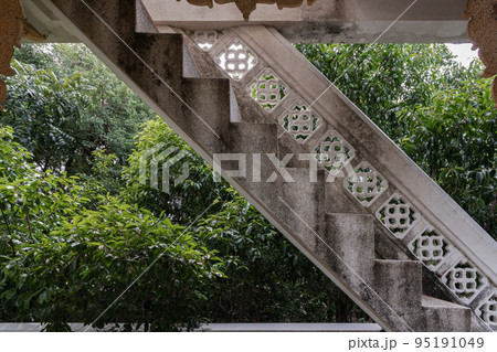 An old traditional cement staircase in the old pavilion and surrounding green trees. An old traditional cement staircase in the old pavilion and surrounding green trees. 95191049