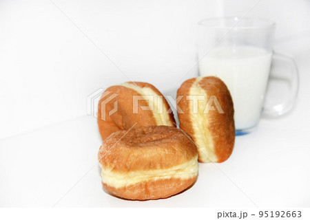 Delicious sweet buns with jam and a glass of milk on a white background. A delicious breakfast of beautifully fried buns and milk. 95192663