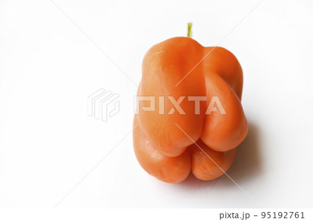 Orange large pepper fruit on a white background. Beautiful ripe pepper close-up. 95192761