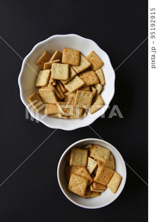 Delicious peppery cookies in a white plate on a black background. 95192915