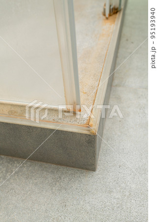 A close-up of shower stall screen with mold, limescale and mildew. 95193940