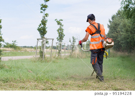 worker cutting grass 95194228