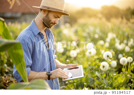 Woman with a digital tablet on flower farm outdoors 95194517