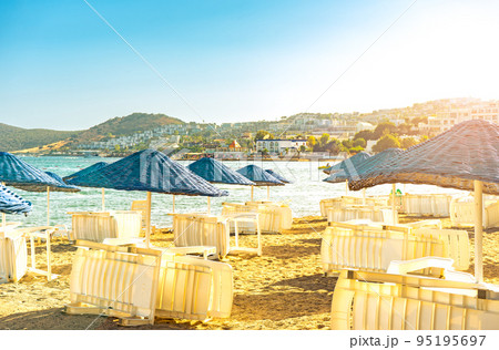 Empty summer beach loungers without people on seaside Empty summer beach loungers without people on seaside 95195697