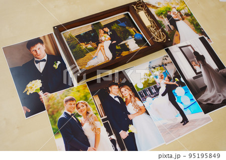 printed wedding photos and a wooden box with a flash drive.  95195849