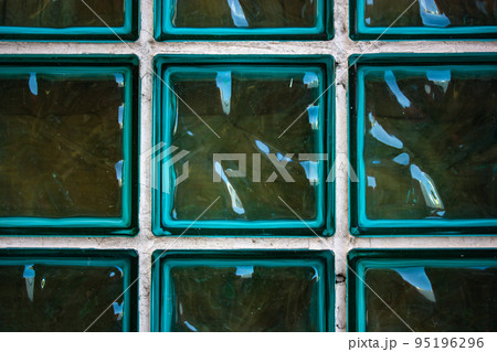 Glass blue green turquoise transparent tile glass wall. Colored glass products for interior, ceramic tile. Glass shiny high glossy blocks for partitions in bathroom. Abstract wallpaper, background. Glass blue green turquoise transparent tile glass wall. Colored glass products for interior, ceramic tile. Glass shiny high glossy blocks for partitions in bathroom. Abstract wallpaper, background. 95196296