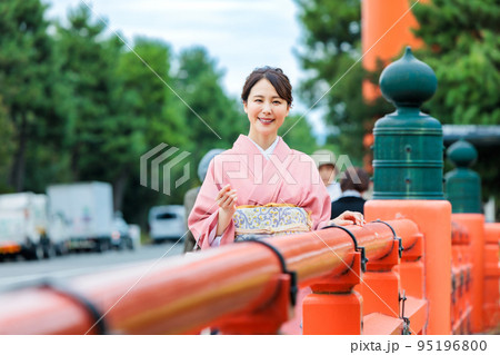 大鳥居の前で京都観光を楽しむ着物姿の女性 95196800