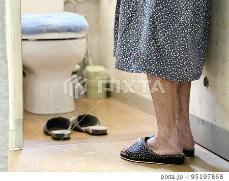 トイレの前に立つ女性の足とスリッパ 95197868