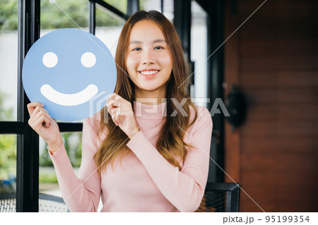 woman smiling showing excellent rating with smiley face icon on blue circle paper 95199354