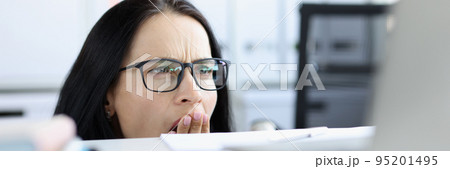 Shocked emotional woman looks from under table at computer Shocked emotional woman looks from under table at computer 95201495