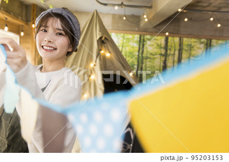おうちキャンプのガーランドで飾付けをする若い女性　家キャン 95203153