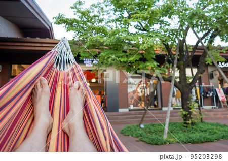 【日本】ハンモックに横たわってリラックスしている男性の裸足の両足 95203298