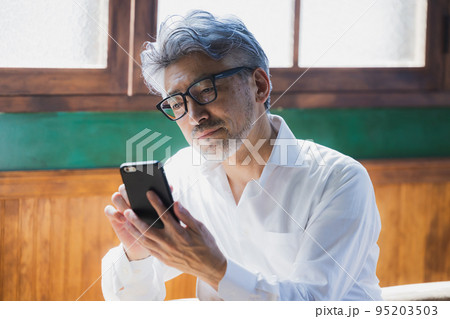 スマホを使うグレイヘアの男性 スマホを使うグレイヘアの男性 95203503