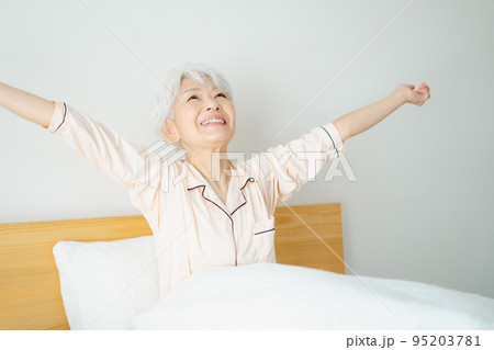 ベッドでストレッチをするシニア女性 95203781