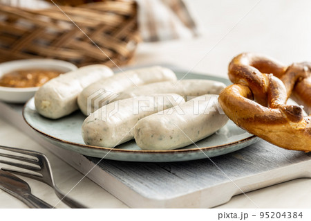 Traditional Bavarian white sausages on plate and pretzes. Traditional Bavarian white sausages on plate and pretzes. 95204384