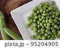 白いお皿に盛られているグリーンピース さや付きあり③ 95204905
