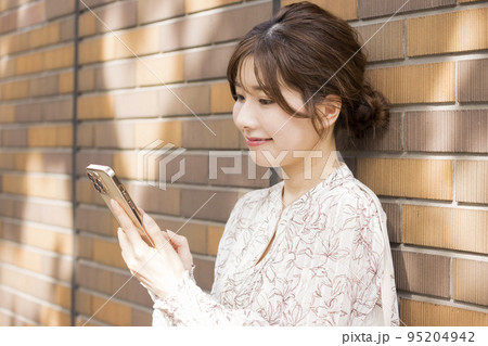 街中でスマートフォンを操作する女性 街中でスマートフォンを操作する女性 95204942