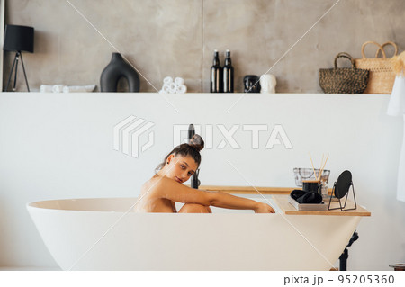 Side view of a woman taking a foam bath at home Side view of a woman taking a foam bath at home 95205360
